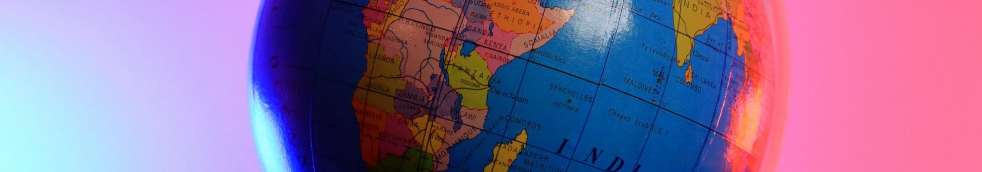 a blue and orange globe with a pink background